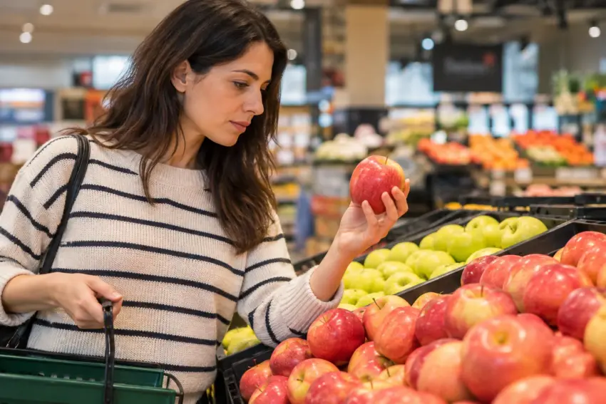 Mulher a escolher maçãs no supermercado